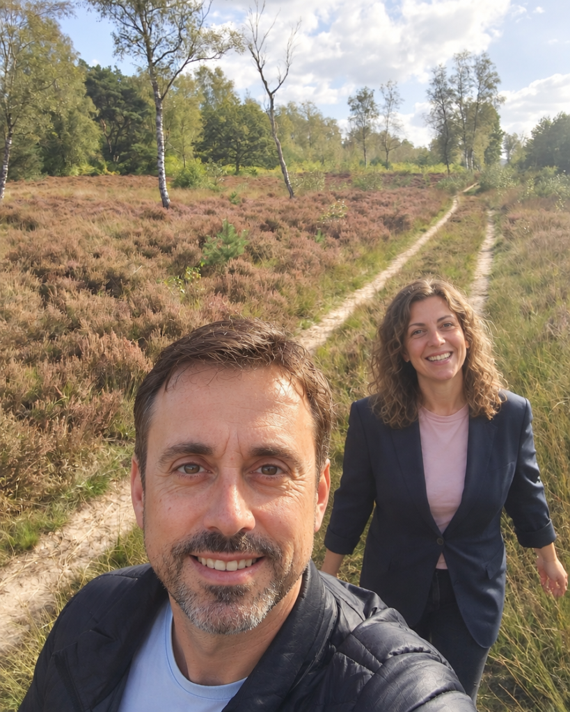 Stel wandelt samen over een zandpad op de Ginkelse Heide tussen heide en berken