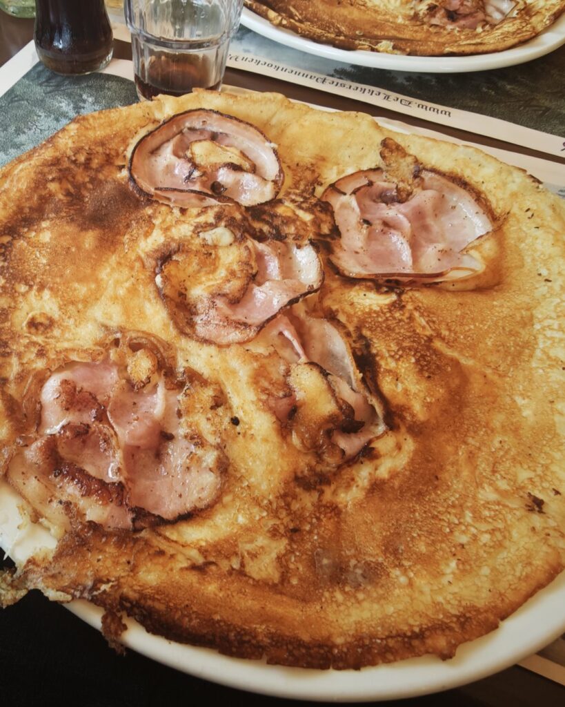 Pannenkoek met spek op een wit bord in pannenkoekenhuis De Vuursche Boer in Lage Vuursche